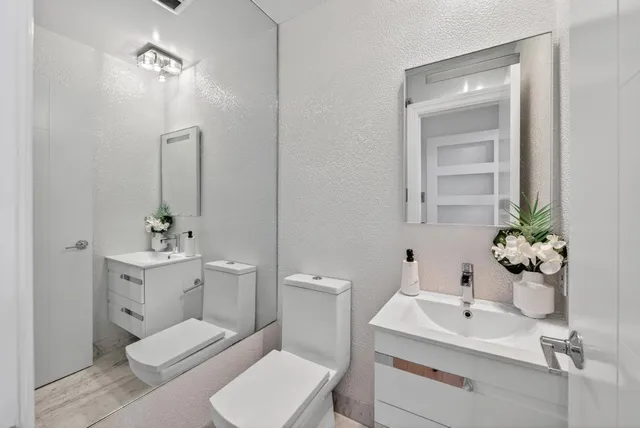 a bedroom with a bed a chair and painting on the wall