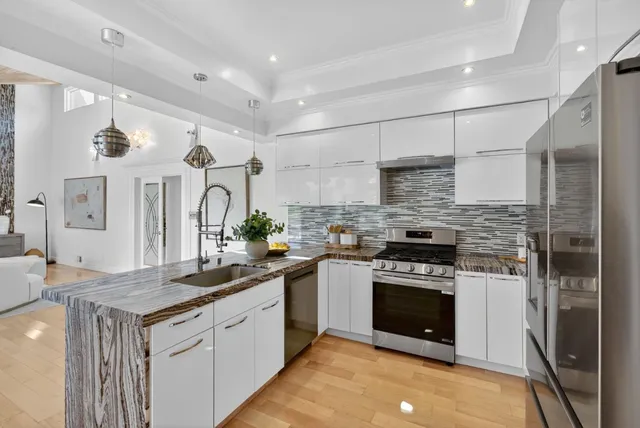 a kitchen with stainless steel appliances granite countertop a stove a sink and a refrigerator