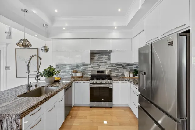 a kitchen with stainless steel appliances granite countertop a sink stove and refrigerator