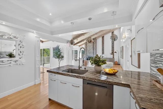 a view of a hallway with wooden floor and a living room