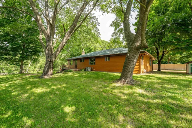 a large kitchen with a large counter top space a sink and stainless steel appliances
