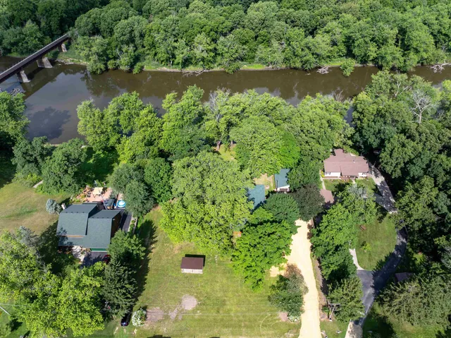 an aerial view of a house with a yard and lake view