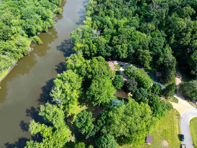 an aerial view of a house with a yard and lake view