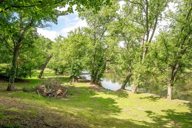 an aerial view of residential houses with outdoor space and lake view