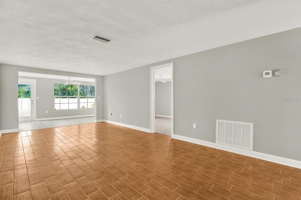 4455 Rustic Drive New Port Richey, FL 34652 - Photo 12 of 27 wooden floor in an empty room with a window