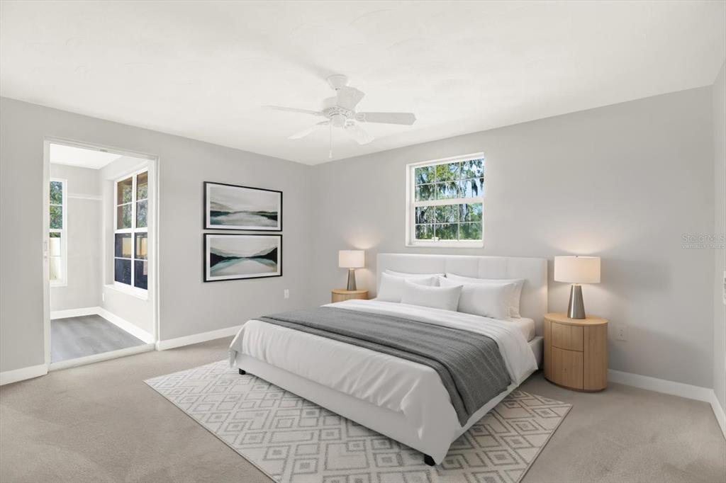 4455 Rustic Drive New Port Richey, FL 34652 - Photo 13 of 27 a bedroom with a large bed a chandelier and windows