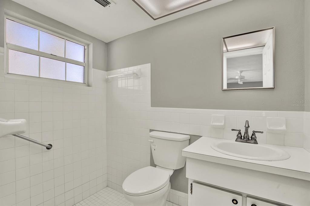 4455 Rustic Drive New Port Richey, FL 34652 - Photo 16 of 27 a white toilet sitting next to a bathroom sink