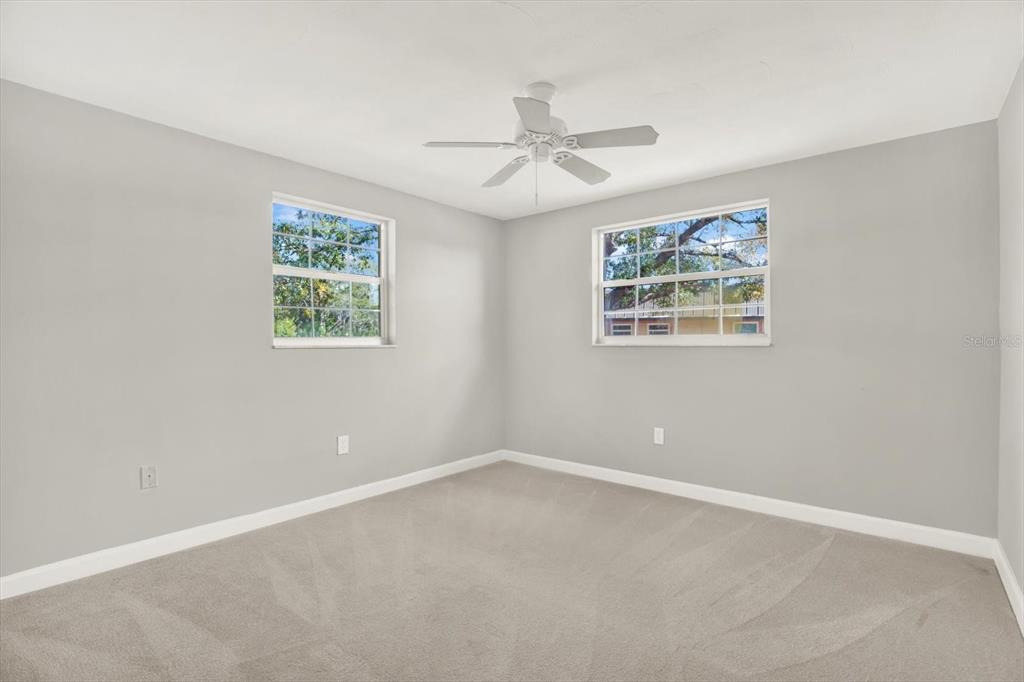 4455 Rustic Drive New Port Richey, FL 34652 - Photo 18 of 27 an empty room with windows and fan
