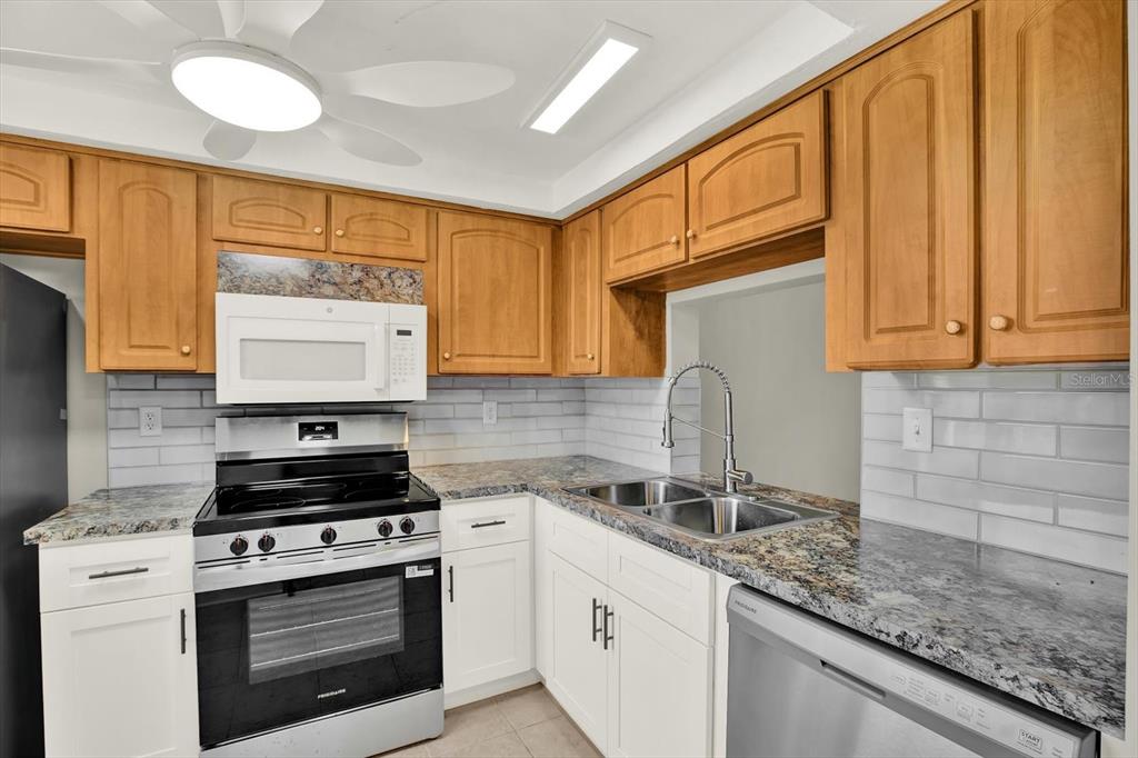 4455 Rustic Drive New Port Richey, FL 34652 - Photo 4 of 27 a kitchen with granite countertop a sink cabinets and stainless steel appliances