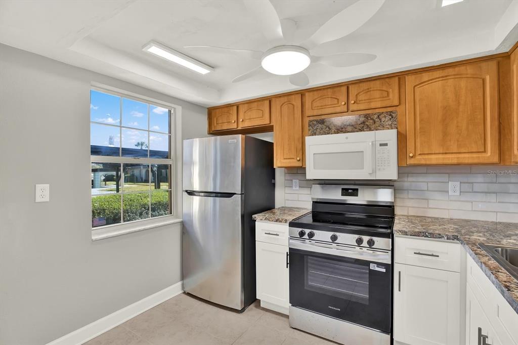 4455 Rustic Drive New Port Richey, FL 34652 - Photo 6 of 27 a kitchen with stainless steel appliances a stove a refrigerator and a sink