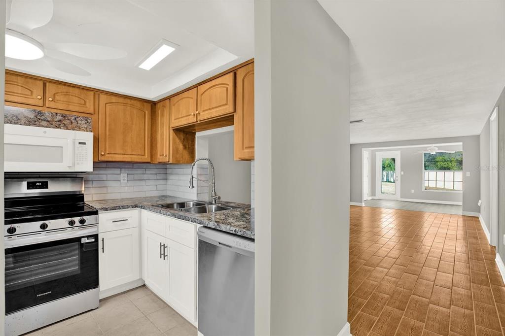 4455 Rustic Drive New Port Richey, FL 34652 - Photo 7 of 27 a kitchen with a stove a sink and a microwave