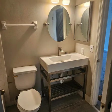 a bathroom with a toilet a sink and mirror