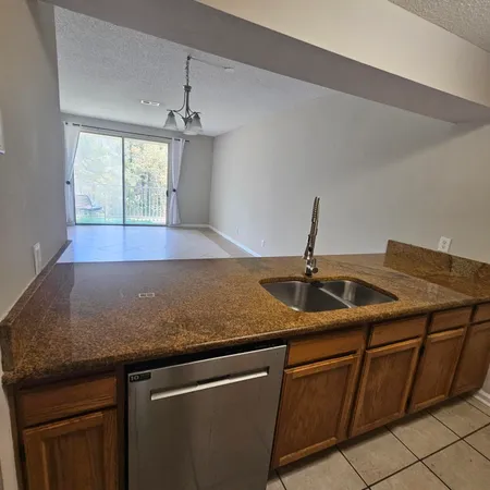 a kitchen with granite countertop a sink and white cabinets
