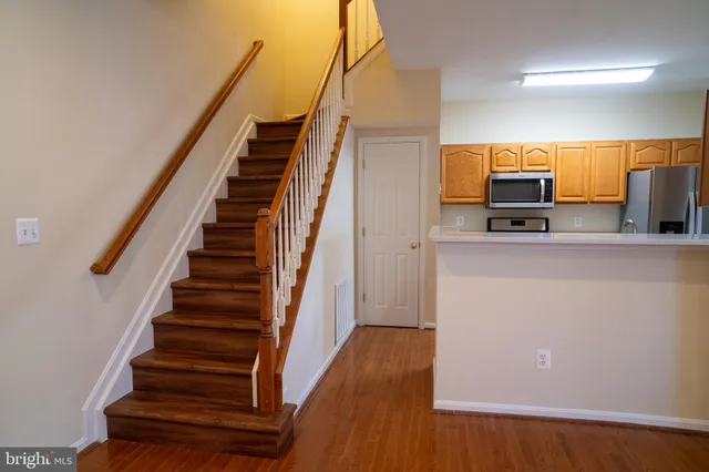 a view of a kitchen with wooden floor and electronic appliances