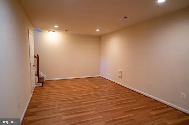 a view of an empty room with wooden floor