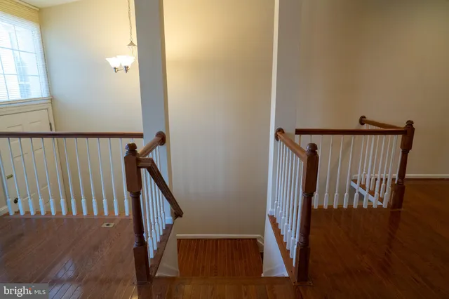 a view of a hallway with wooden floor and stairs