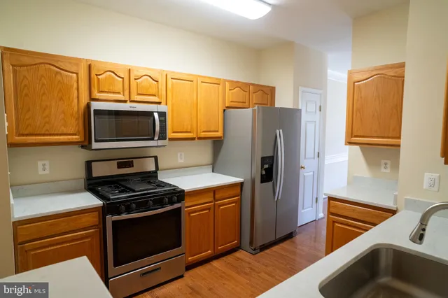 a kitchen with stainless steel appliances a stove a microwave and a sink