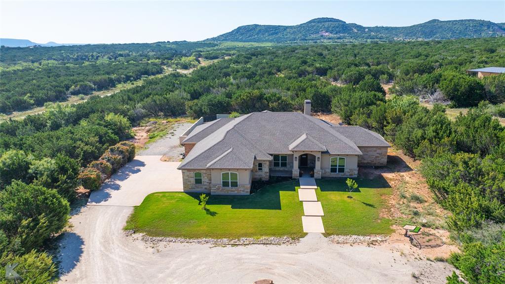 a aerial view of a house with a big yard and large trees