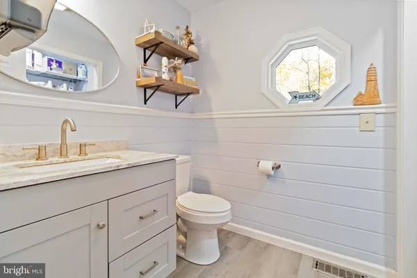 a bathroom with a toilet a sink and mirror