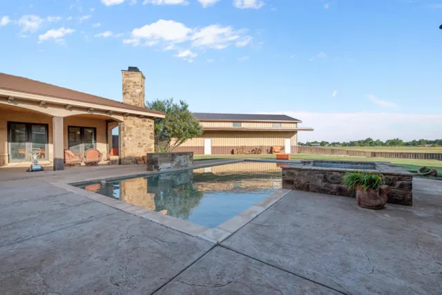 a view of a swimming pool with an outdoor seating and a yard