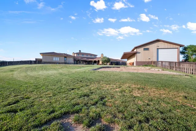 a view of a house with a big yard and large tree