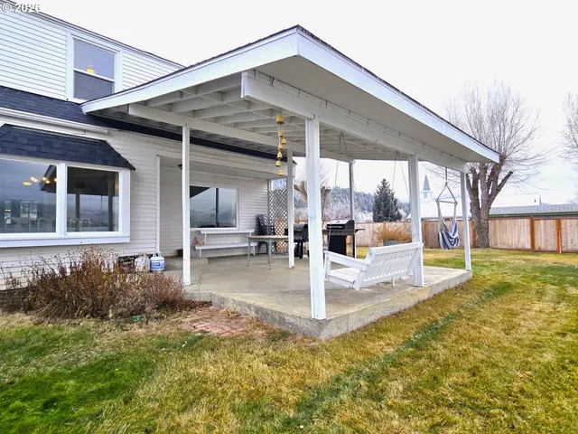 a view of a house with backyard and sitting area