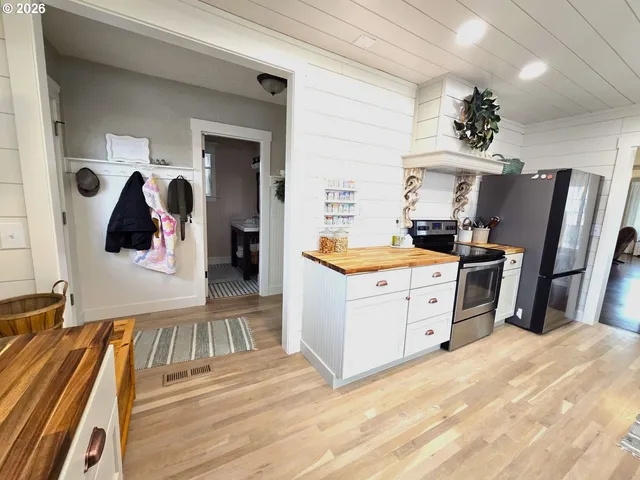 a kitchen with a refrigerator and wooden floor