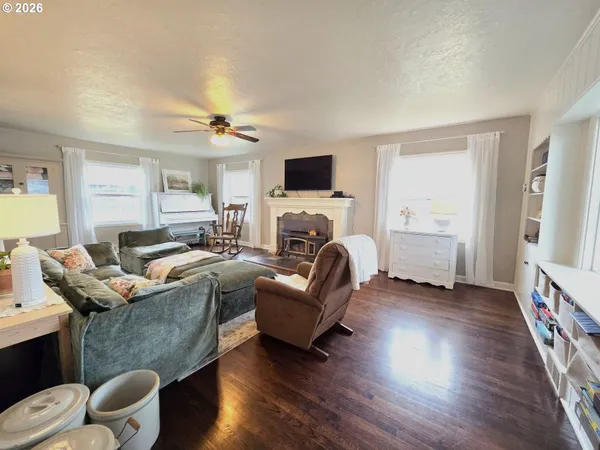 a living room with furniture hard wood floor and a ceiling fan