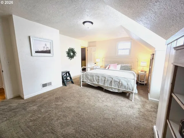 a dining room with kitchen island stainless steel appliances furniture a rug and a view of kitchen