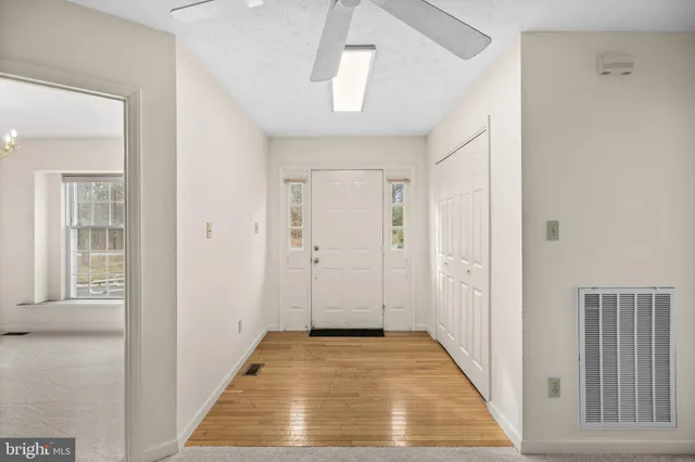 a view of a hallway with wooden floor and staircase