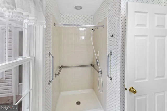 a bathroom with a tub shower hardwood and a sink