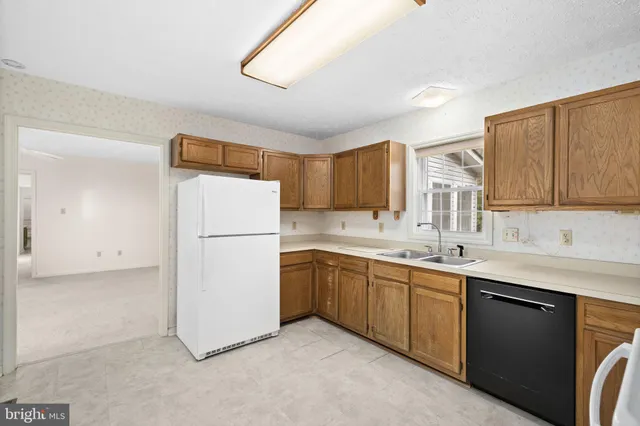 a kitchen with a sink a refrigerator and cabinets