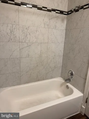 a spacious bedroom with a bed and wooden floor