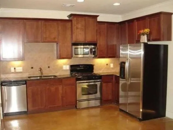 a kitchen with granite countertop stainless steel appliances and wooden cabinets
