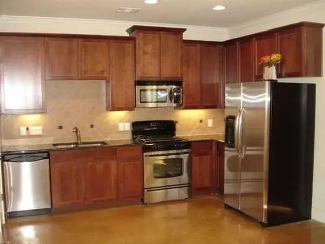 a kitchen with granite countertop stainless steel appliances and wooden cabinets