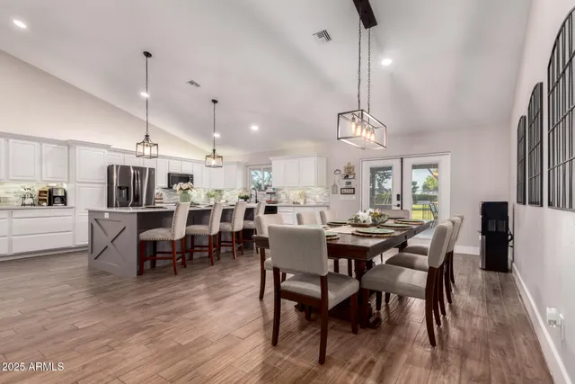 a large kitchen with lots of counter space a sink dining table and chairs
