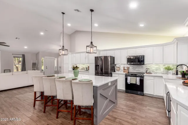 a kitchen with stainless steel appliances a sink stove refrigerator and cabinets