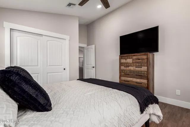 a bedroom with a bed and a flat tv screen on the dresser
