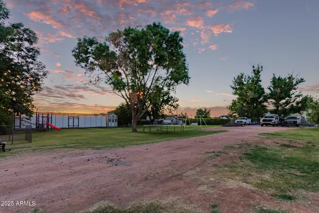 a view of grassy field with benches and trees all around