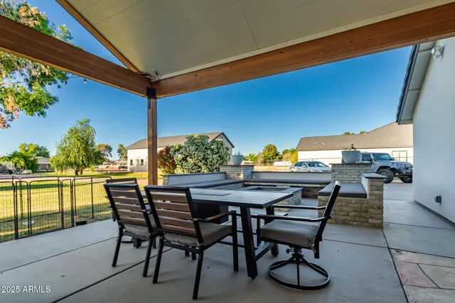 a view of swimming pool with lawn chairs and plants