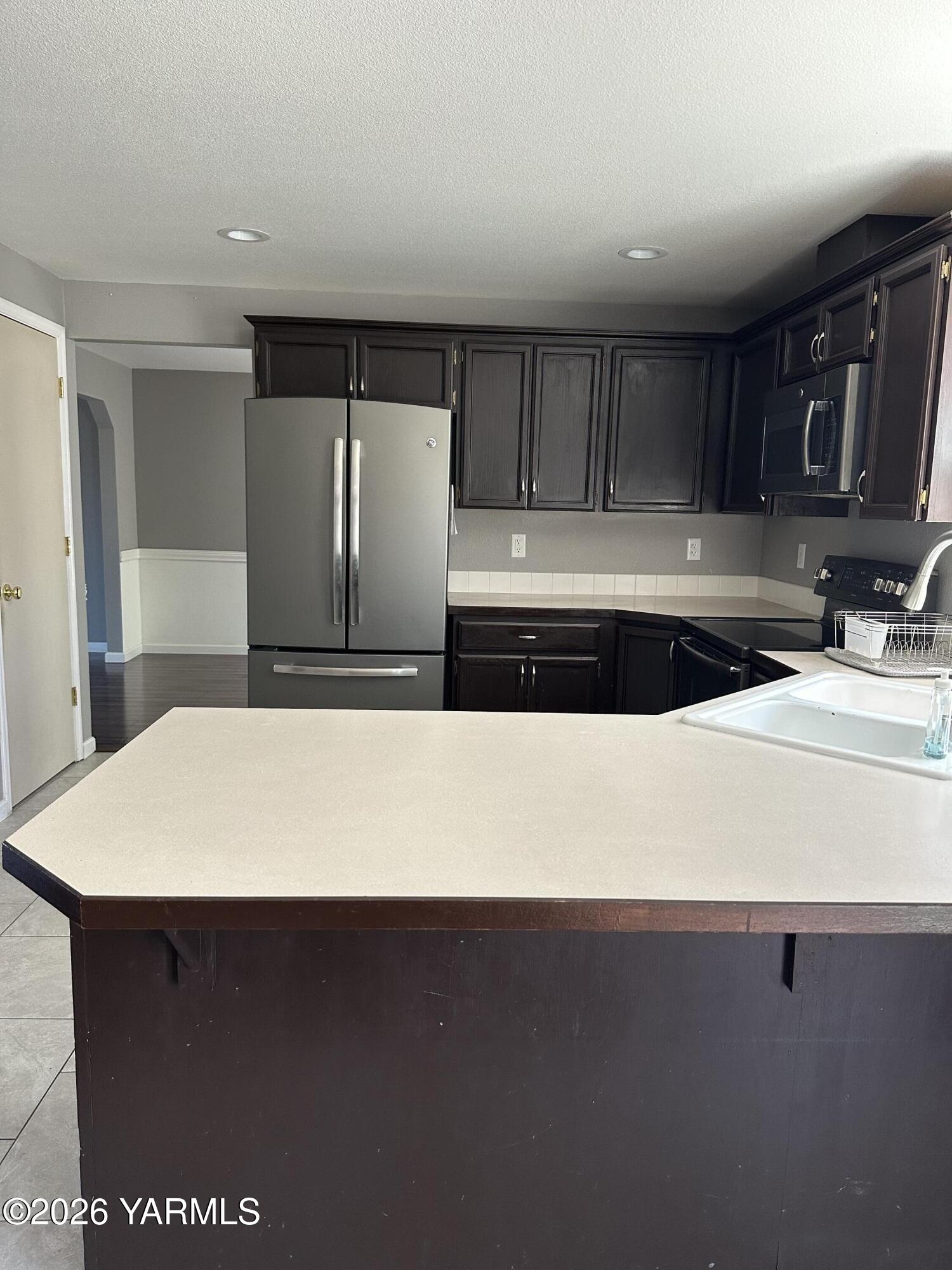 514 Cascade Avenue Moxee, WA 98936 - Photo 23 of 25 a kitchen with a sink and a refrigerator