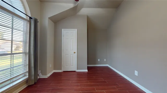 wooden floor in an empty room with a window