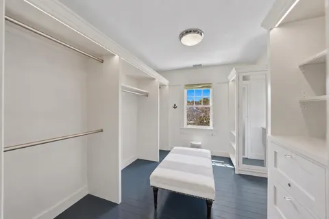a view of empty room with wooden floor and window