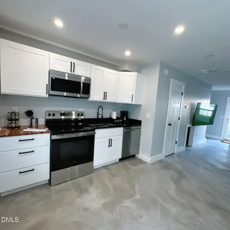 a kitchen with stainless steel appliances granite countertop a refrigerator a sink a stove a microwave and wooden cabinets