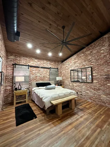 a large room with a bed and wooden floor