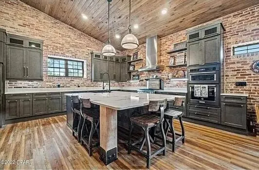 a kitchen with stainless steel appliances a stove a sink dishwasher and a refrigerator with wooden cabinets