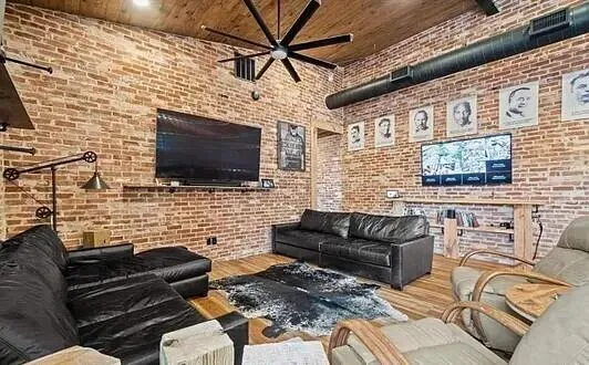 a living room with couches a flat screen tv and a fireplace