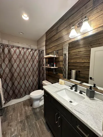 a bathroom with a double vanity sink toilet and mirror