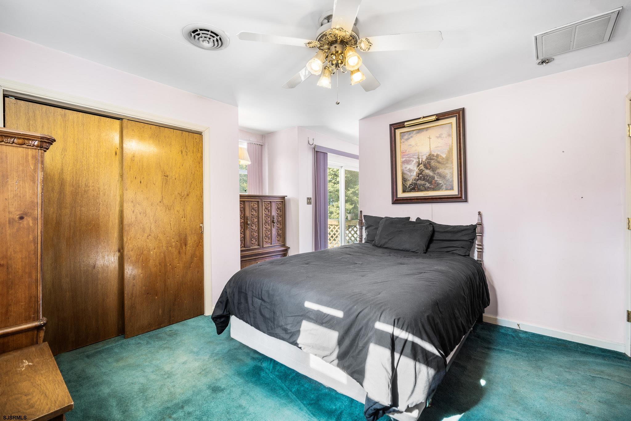 123 Bayview Drive Absecon, NJ 08201 - Photo 14 of 23 a bedroom with a large bed and a chandelier