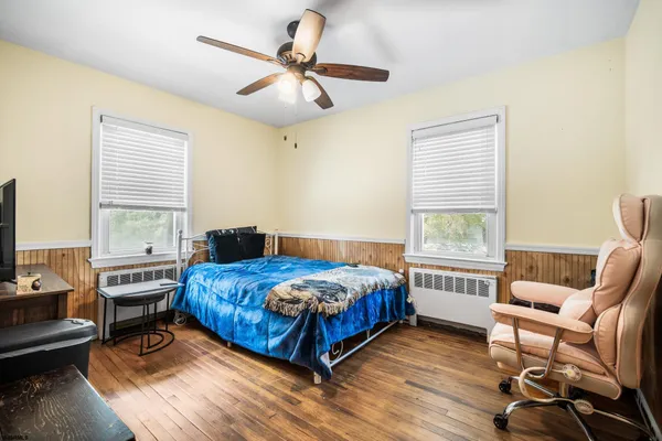 a bedroom with a bed a chair and a chandelier